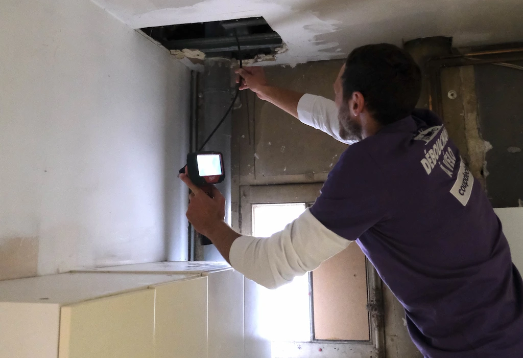 Technicien Coup de clé inspectant une canalisation bouchée avec camera