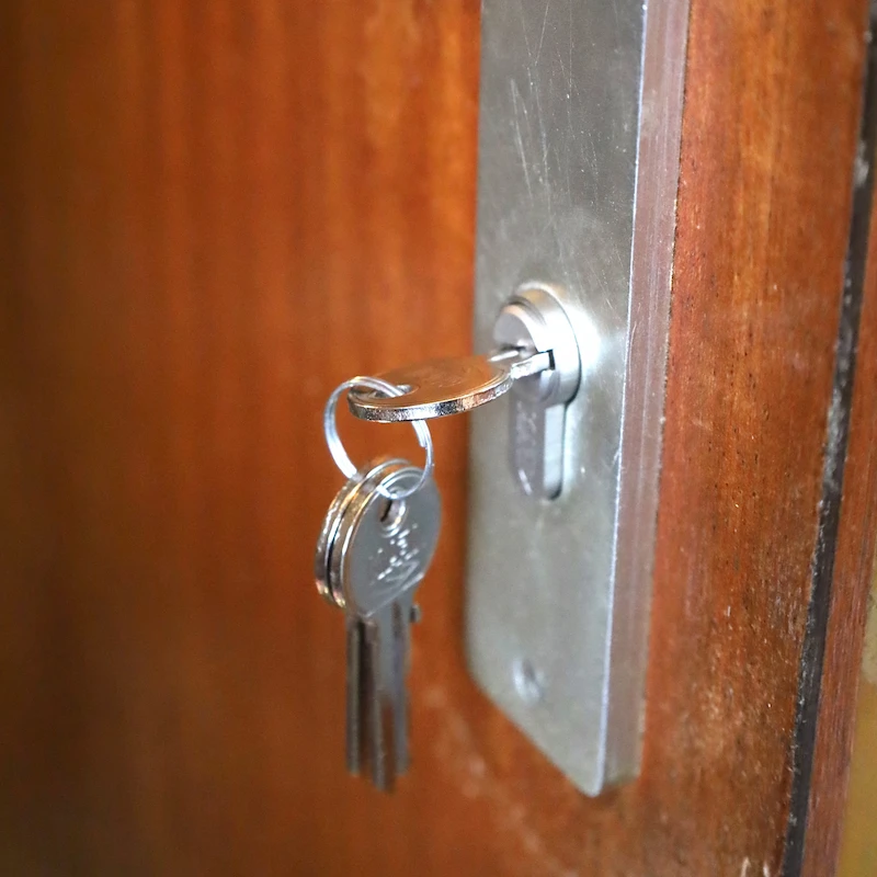 Clé insérée dans une serrure de porte avec porte-clés