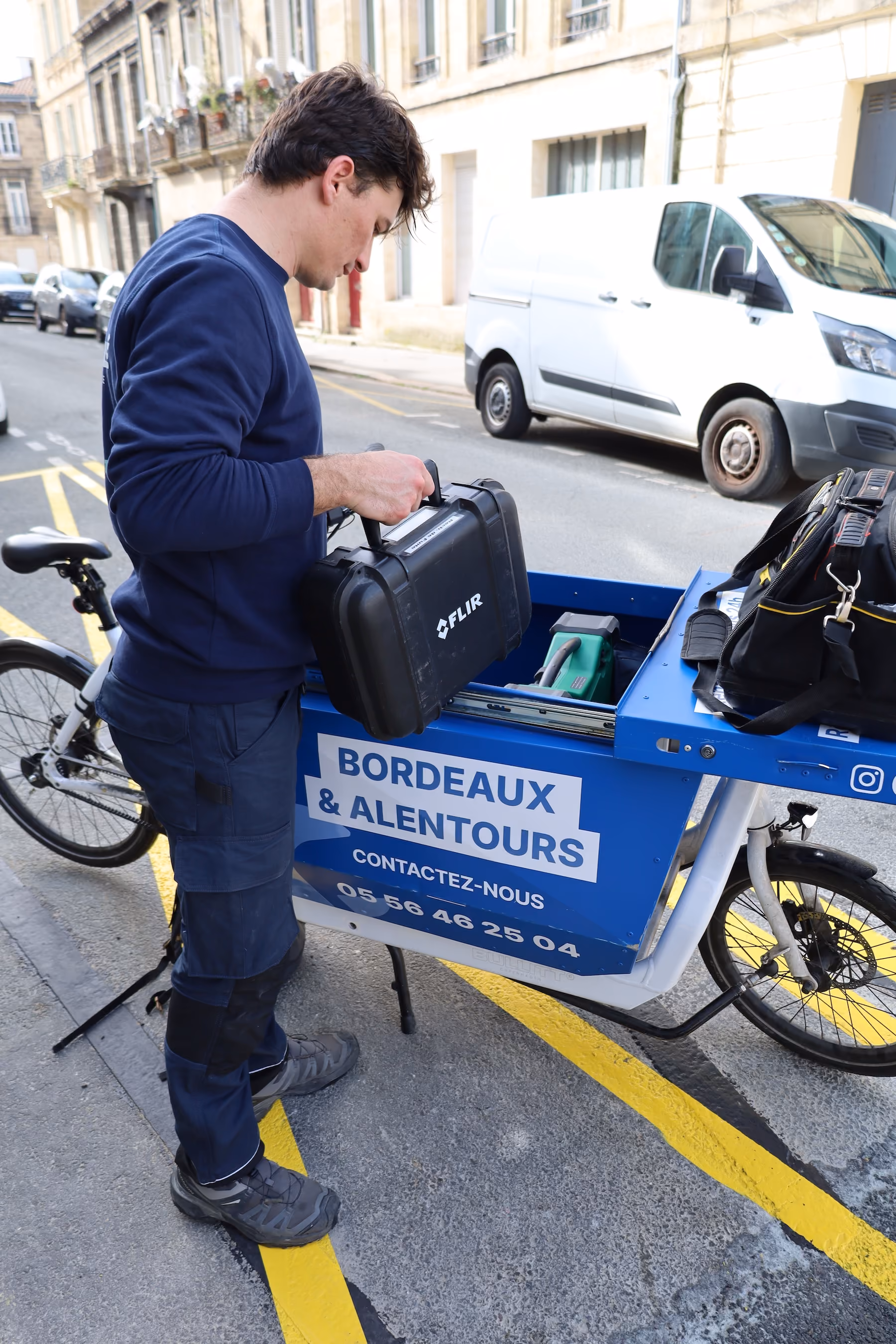 Technicien Coup de clé arrivant à vélo cargo pour un diagnostic