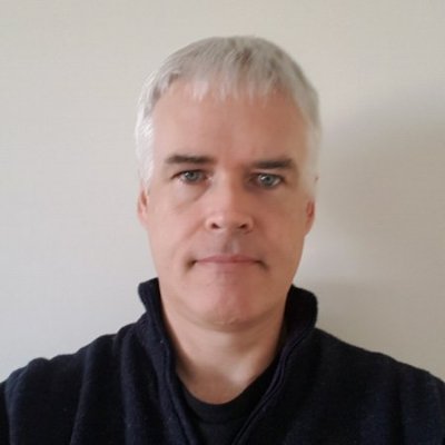 A profile picture of Steve Miller. He short gray hear and a dark top on. He is looking intently but warmly into the camera.