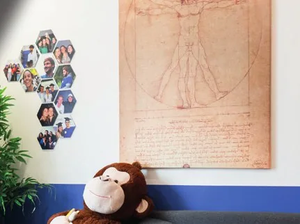 Mur des locaux d’Avicenne : photos d’étudiants dans des cadres hexagonaux, à côté de l’Homme de Vitruve