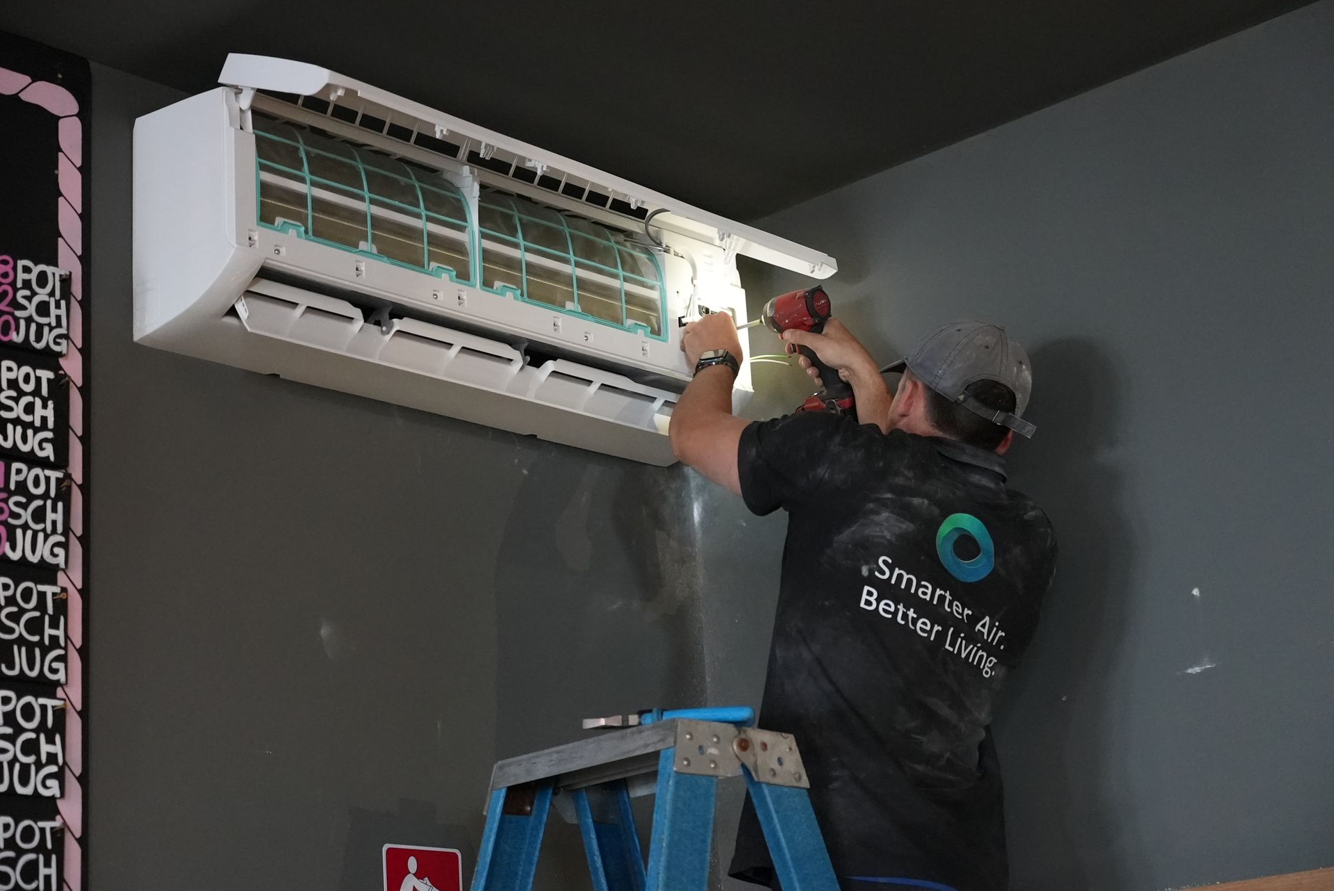 Oz Air Group technician installing a split system air conditioner on a Melbourne wall