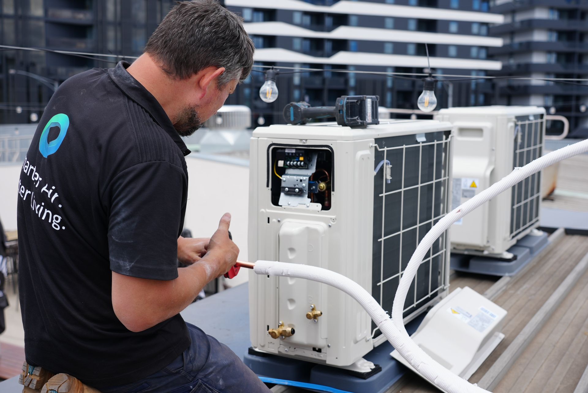 Oz Air Group technician installing an outdoor air conditioning condenser unit