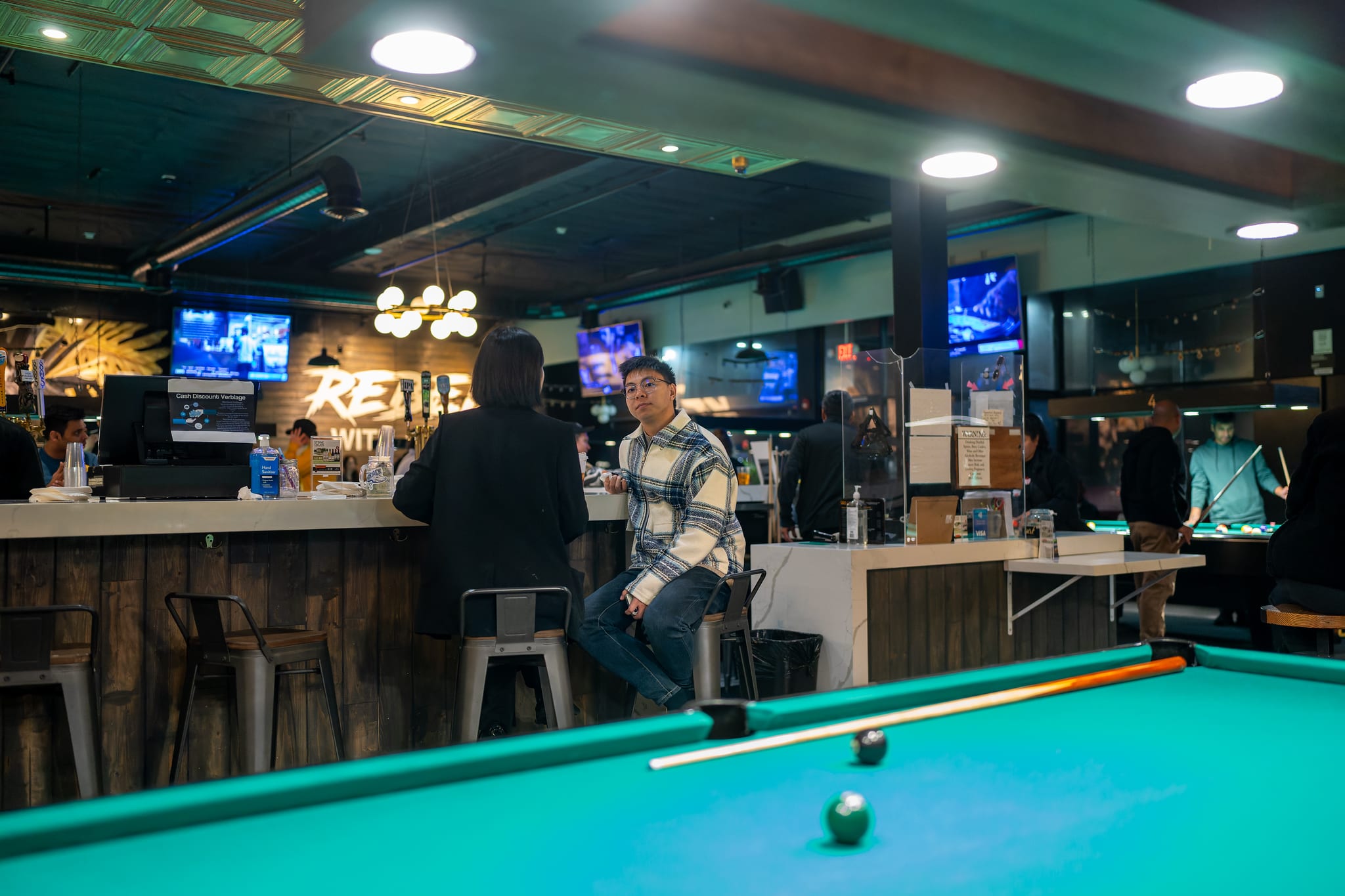 Guests seated at the grand bar at 946 Billiards