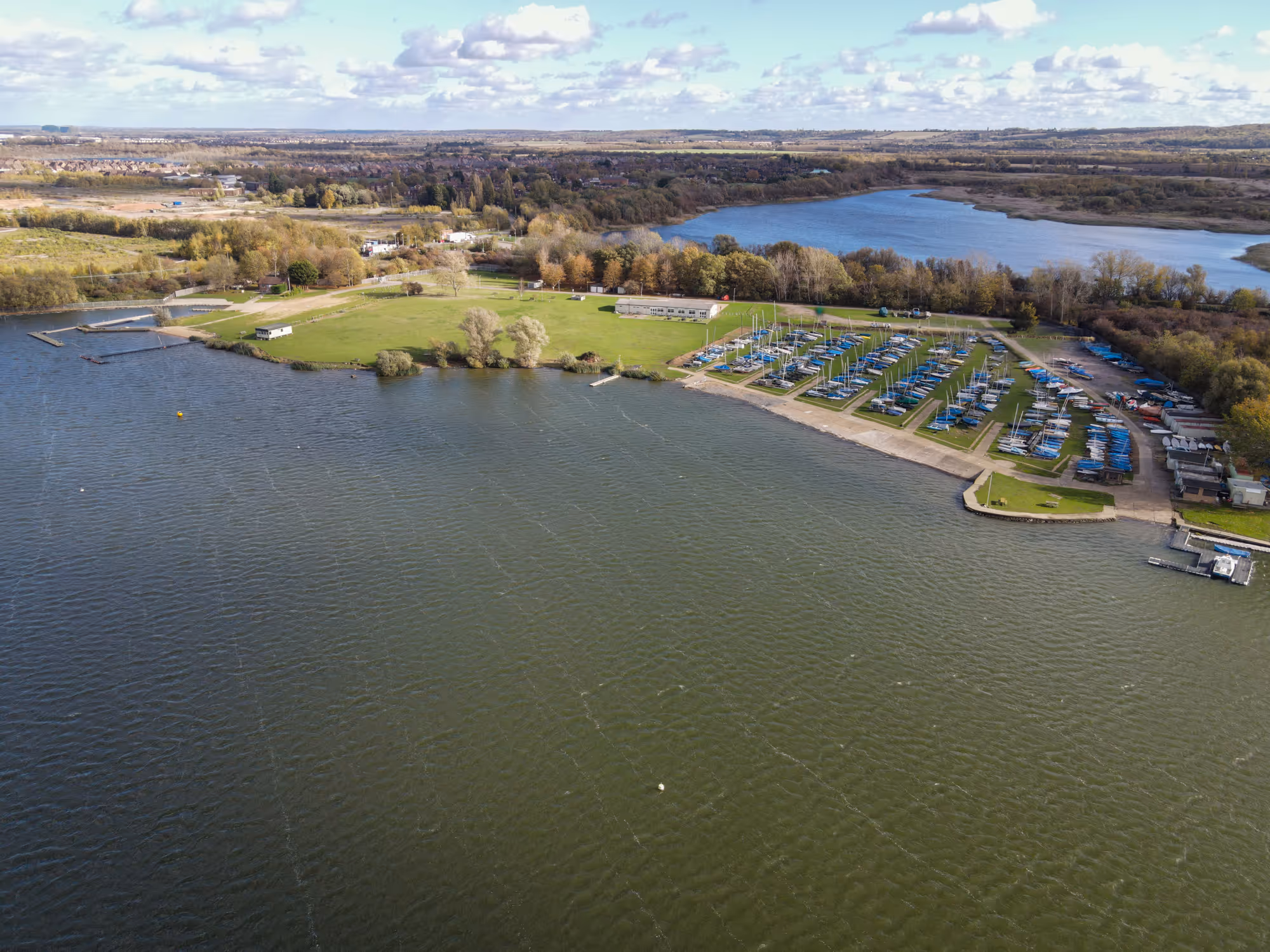 Aerial view of a lakeside. Showing clubhouse, dinghy park, launching, angling area and ski, wakeboard and powerboat areas.
