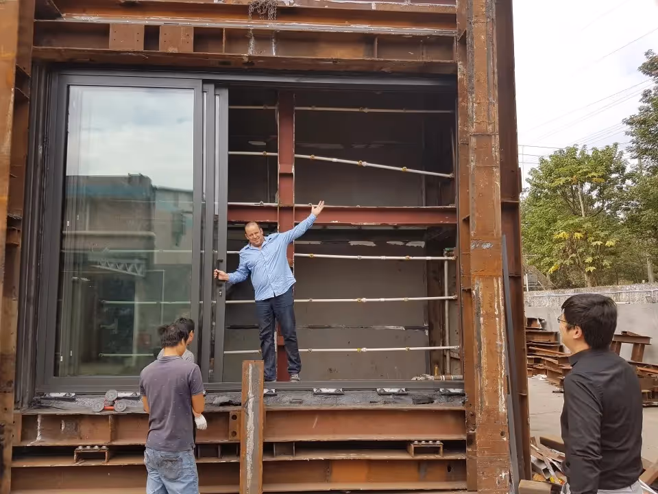 Four men outside building under construction.