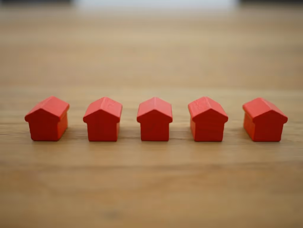 Five small wooden houses on a table.