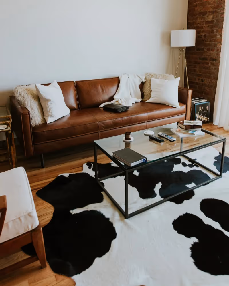 Modern living room with couch and cow pattern rug.