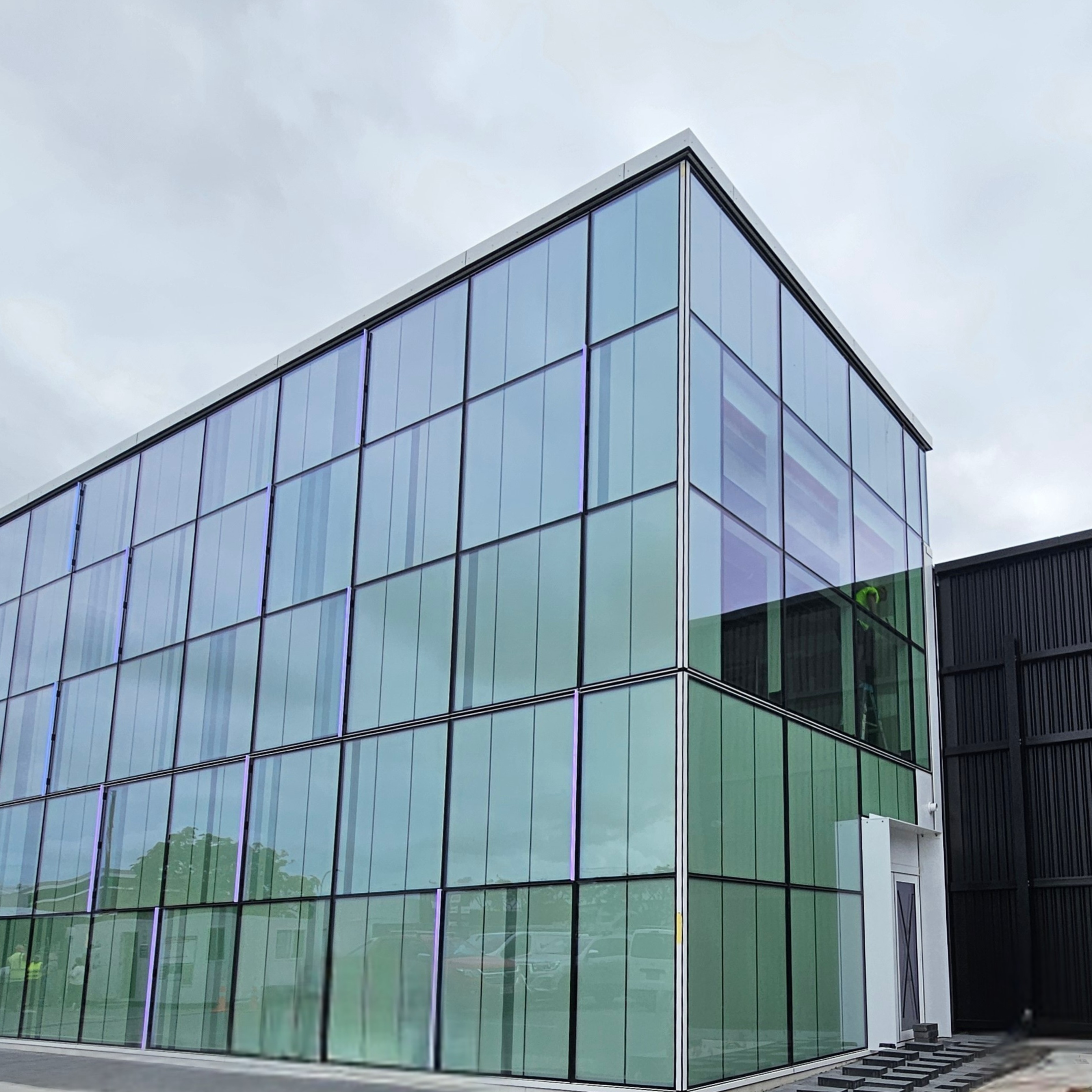 Exterior of the Hawke's Bay Regional Museum Research and Archives Centre, featuring a sleek, modern design with a prominent glass facade. 