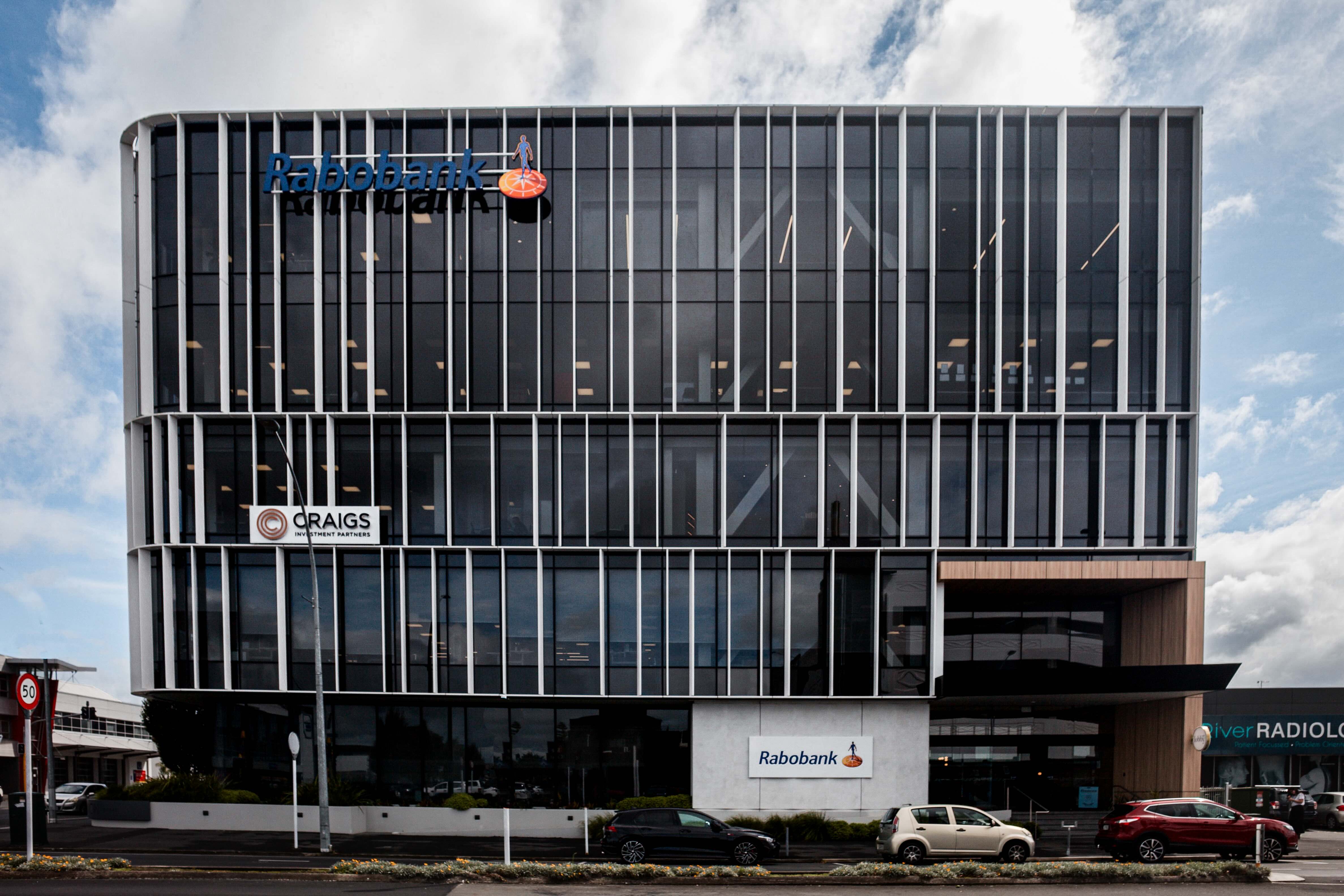 Union Square Office Development, Building F – A modern commercial building in Hamilton, New Zealand, featuring a sleek glass façade with vertical fins. Visible signage includes Rabobank and Craigs Investment Partners.