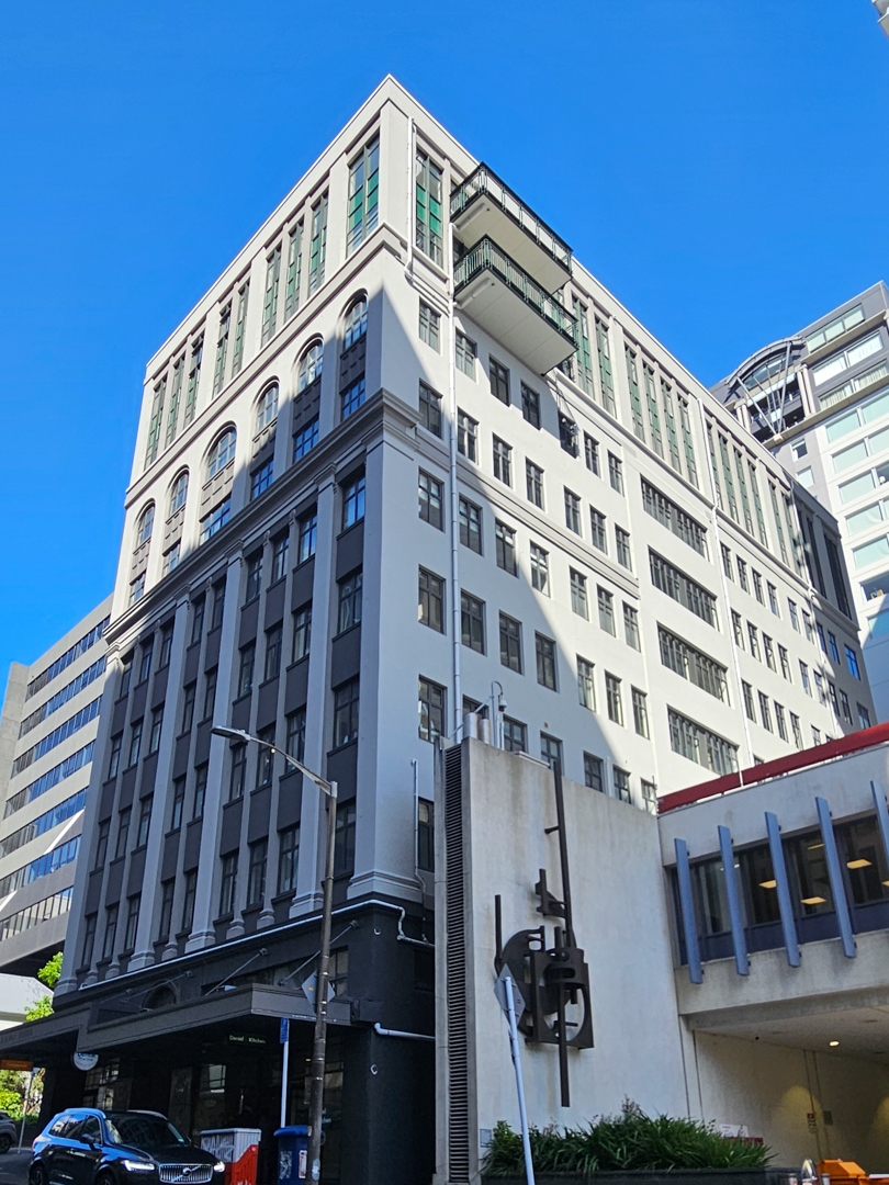 The tall facade of Kelvin House in Wellington, a heritage building undergoing remediation with warm roof and window upgrades.