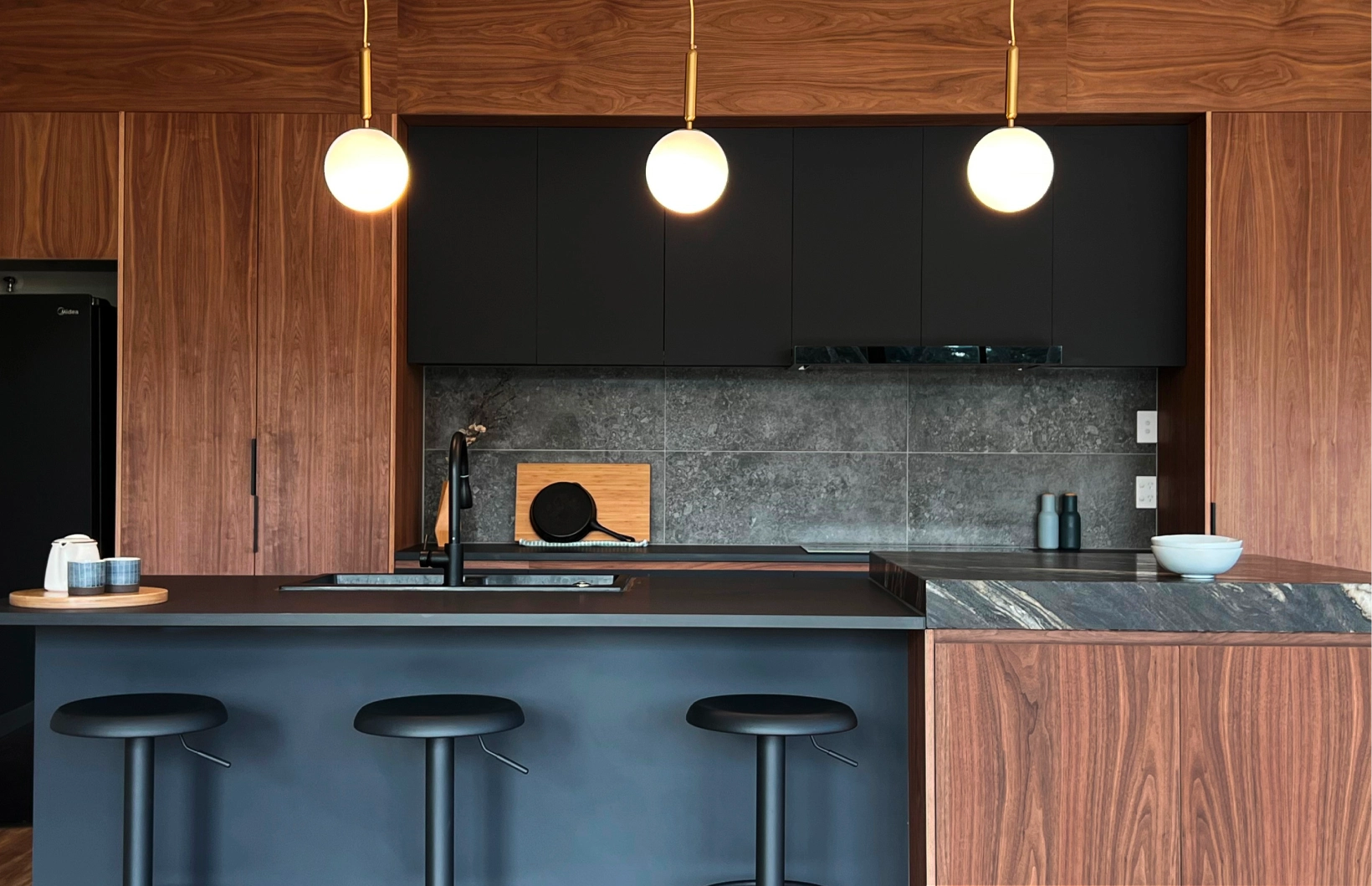 Award winning interior design of a kitchen featuring a dark brown and black colour scheme