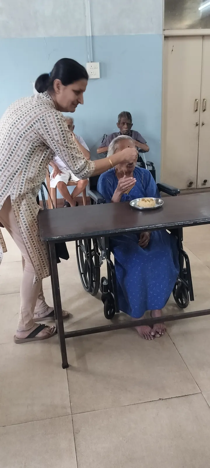 Caregiver attending warmly to a resident — the breadth of care