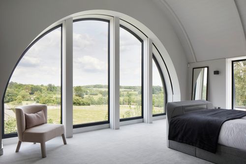 Master bedroom with striking window and landscape views