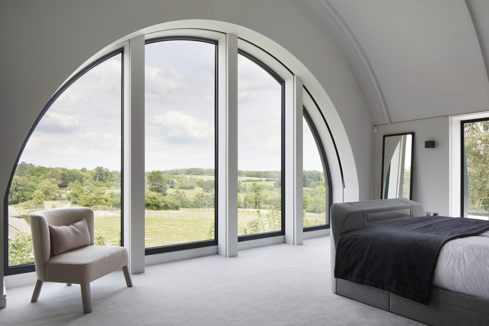 Master bedroom with striking window and landscape views