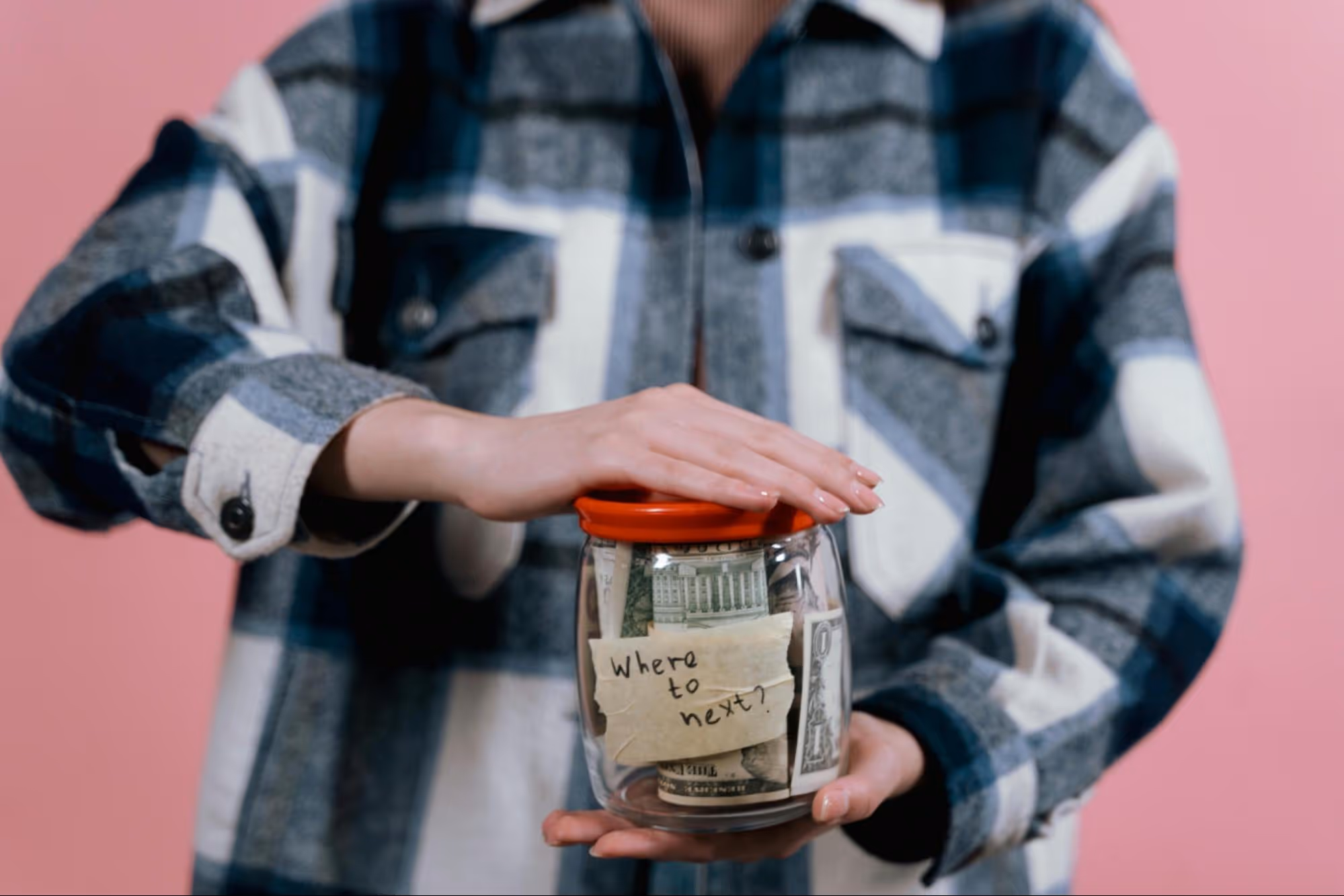 Woman holding a jar against a pink background