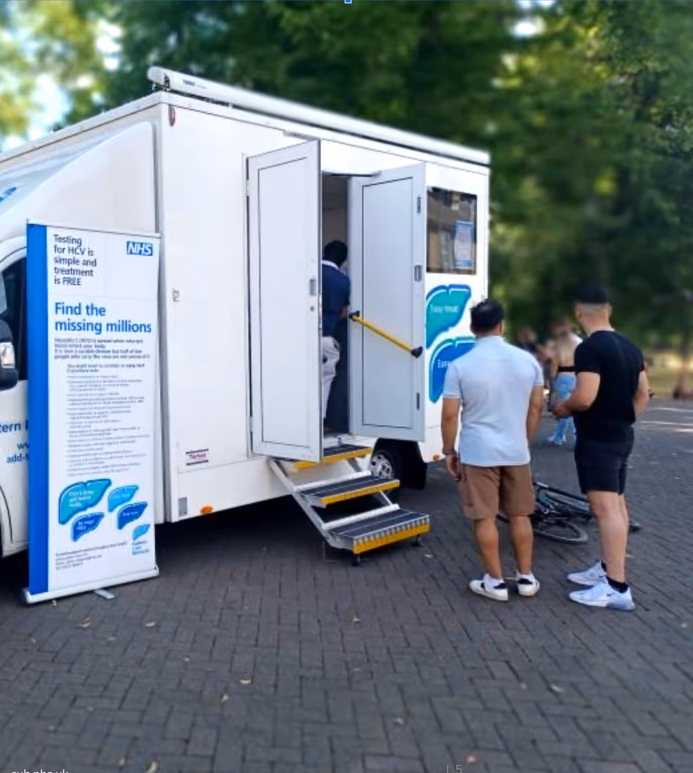 Two men stood outside a mobile testing station