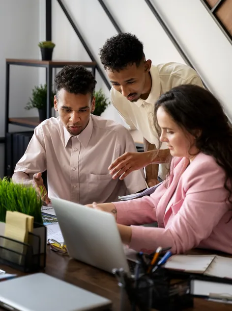 Colleagues working together on a laptop at a desk
