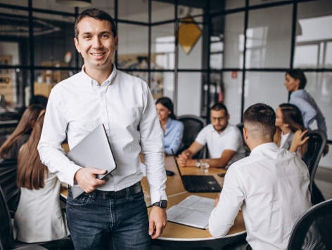 Team working at a shared table while a colleague takes a call