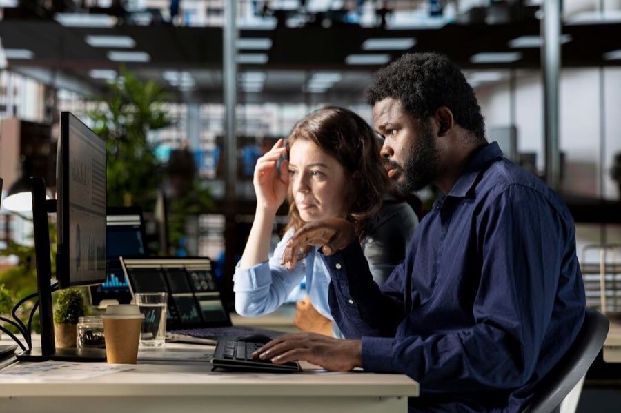 Team working at a shared table while a colleague takes a call
