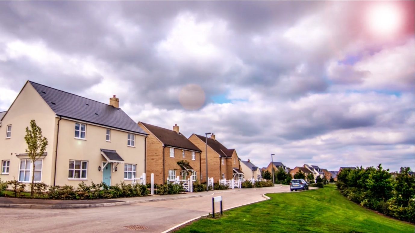 A row of houses with a road and grassAI-generated content may be incorrect.