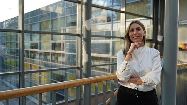 Monika stojąa na tle okna