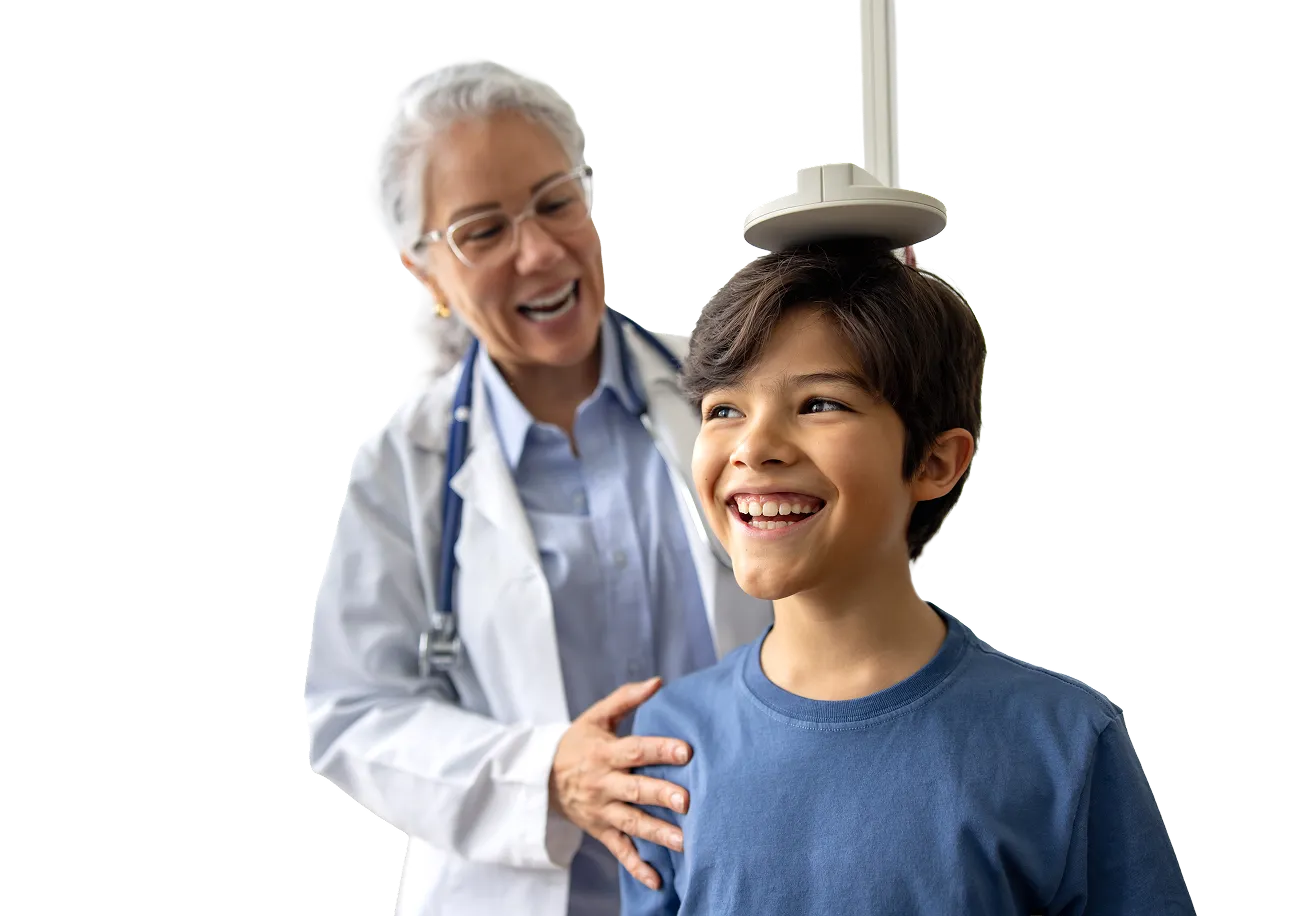 Doctor measuring a smiling boy’s height during a medical check-up.