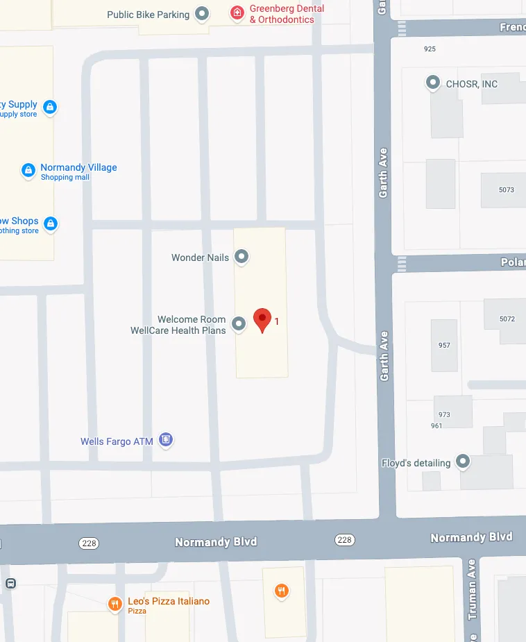 Smiling female doctor in white coat interacting with a young girl wearing hair clips and a pink sweater.