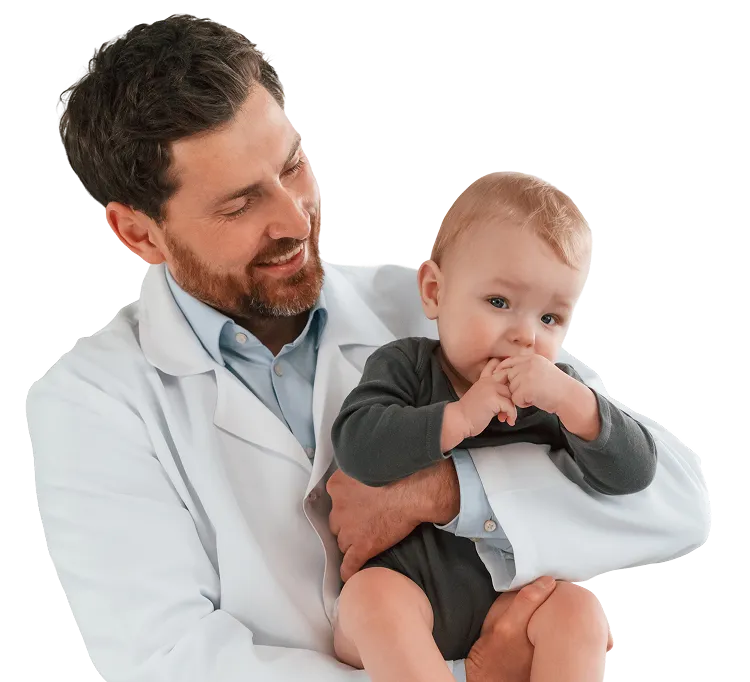 Smiling male doctor holding a baby who is sucking on their fingers.