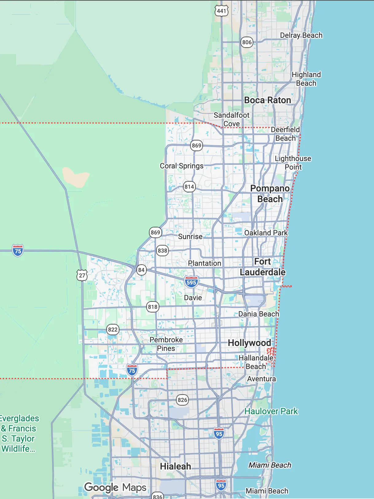 Smiling female doctor in white coat interacting with a young girl wearing hair clips and a pink sweater.