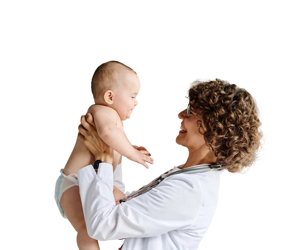Smiling female pediatrician with curly hair holding a happy baby wearing a diaper.