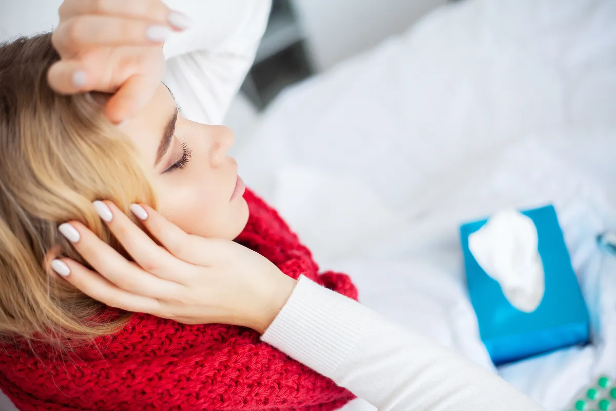 A woman with the flue having a headache