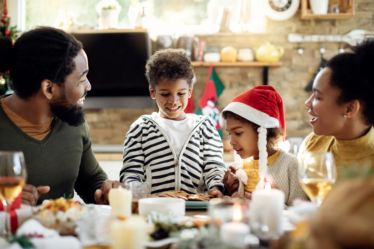 Happy family having cookies for desert after Christmas lunch at home.