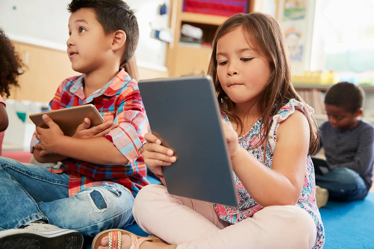 Children looking at tablets in the kindergarten