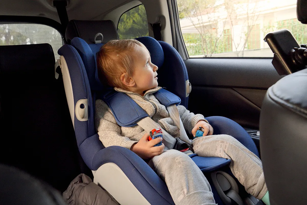 Child in a child's see tin a car