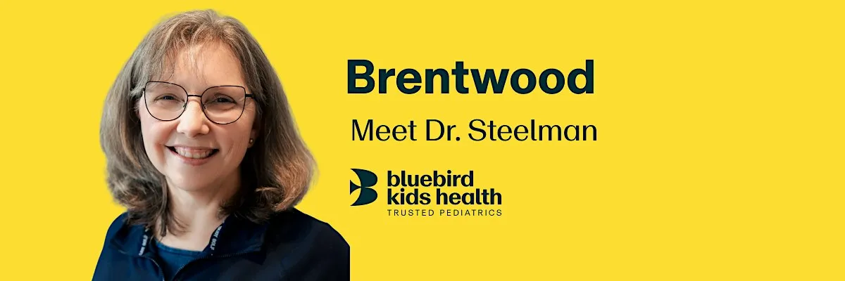 Expectant couple embracing and smiling on a Bluebird Kids Health event banner for the Brentwood practice