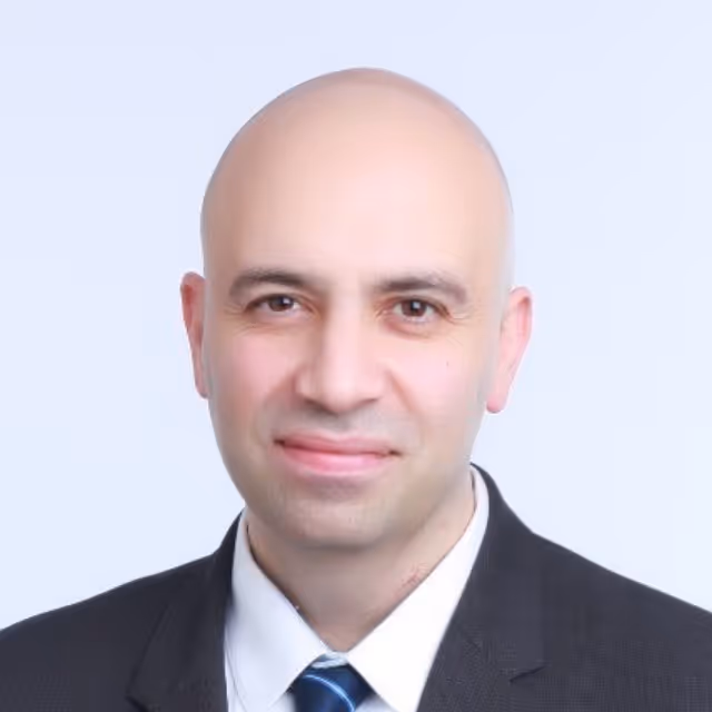 Portrait of a bald man in a suit and striped tie against a light background.