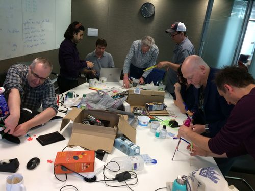 A group of people making and crafting with recyclables during a workshop.