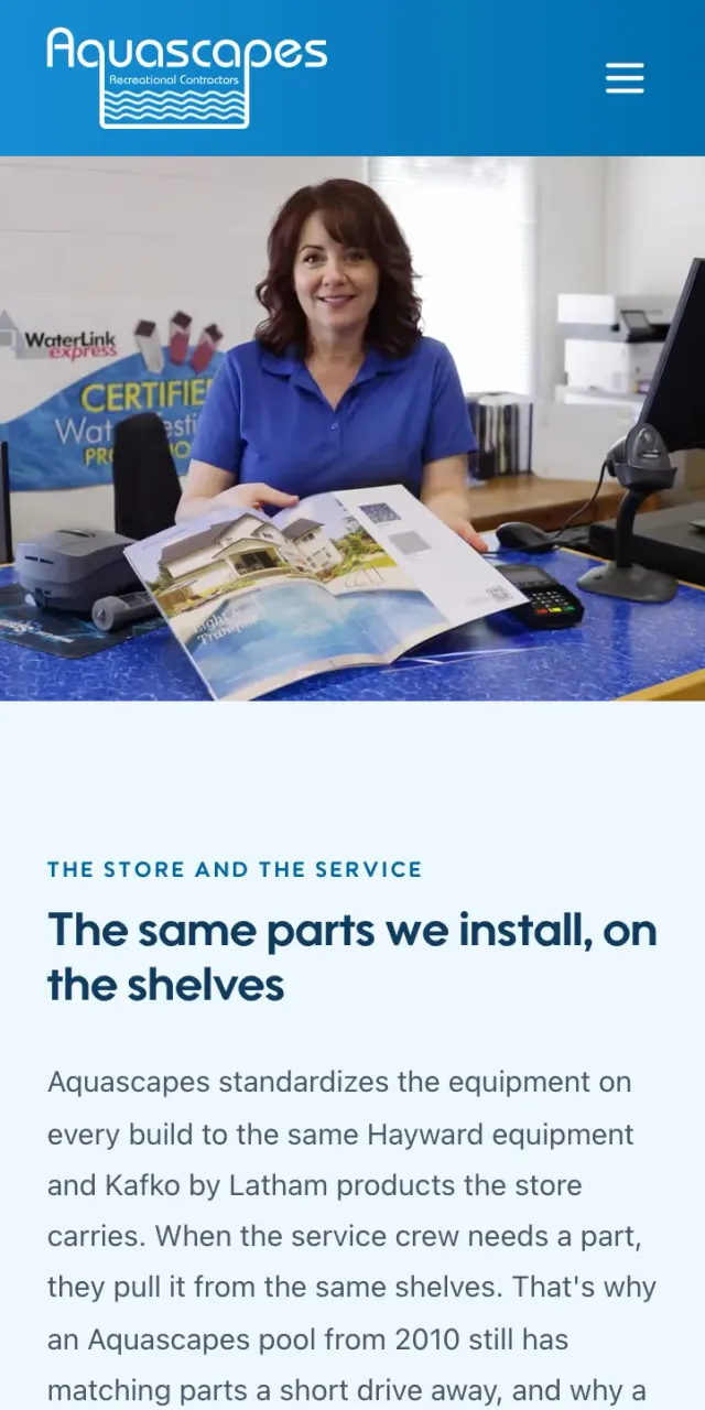 The retail store page at phone width: a staff member at the counter with a product catalogue.