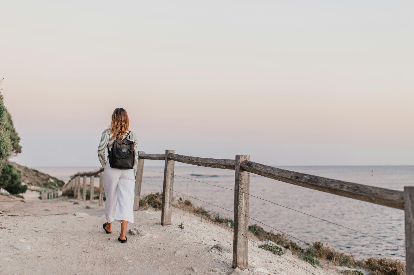 Digitale Nomade läuft am Strand mit Rucksack
