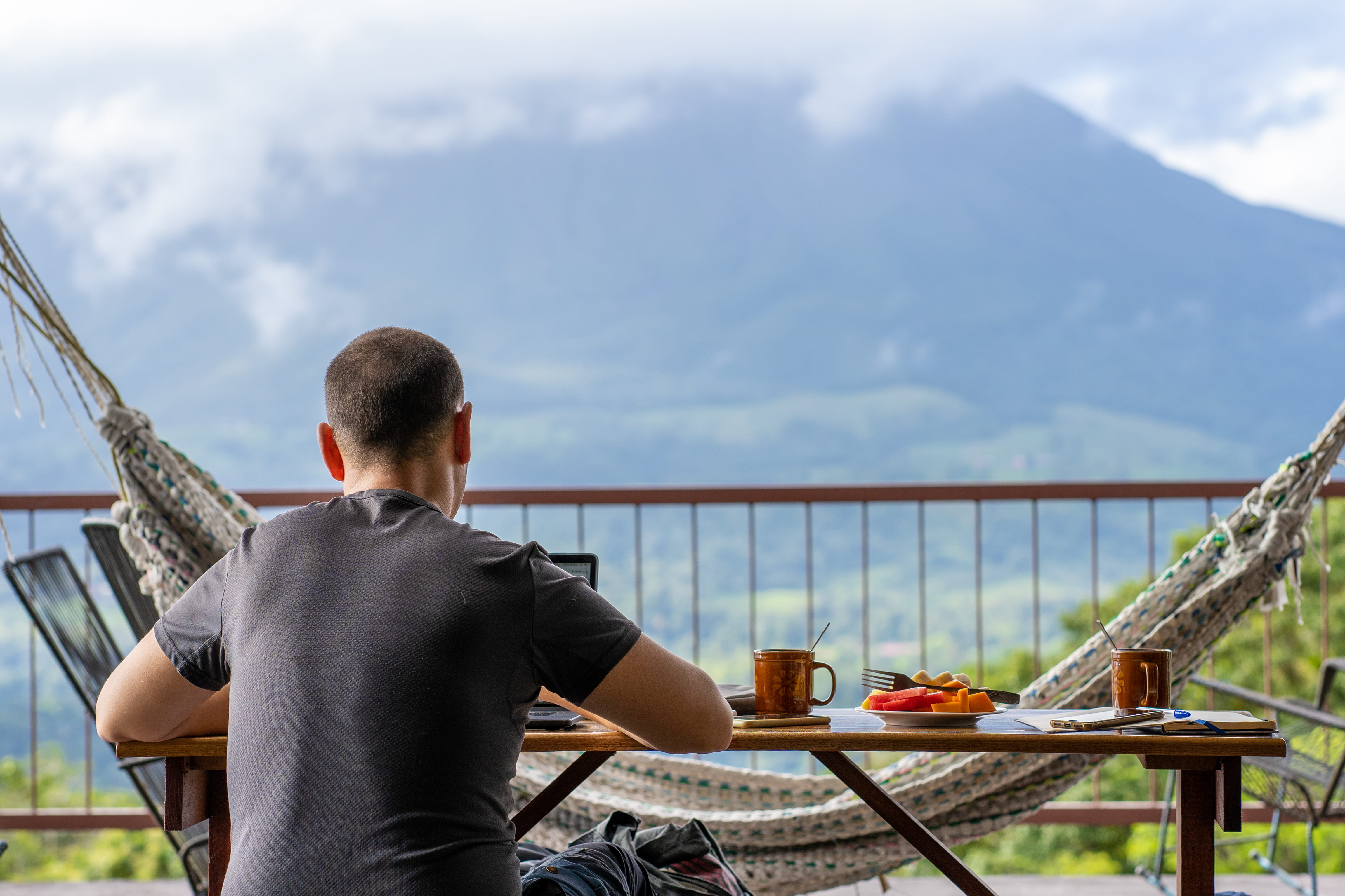 Digitaler Nomade arbeitet auf seiner Terrasse mit Bergblick in Costa Rica
