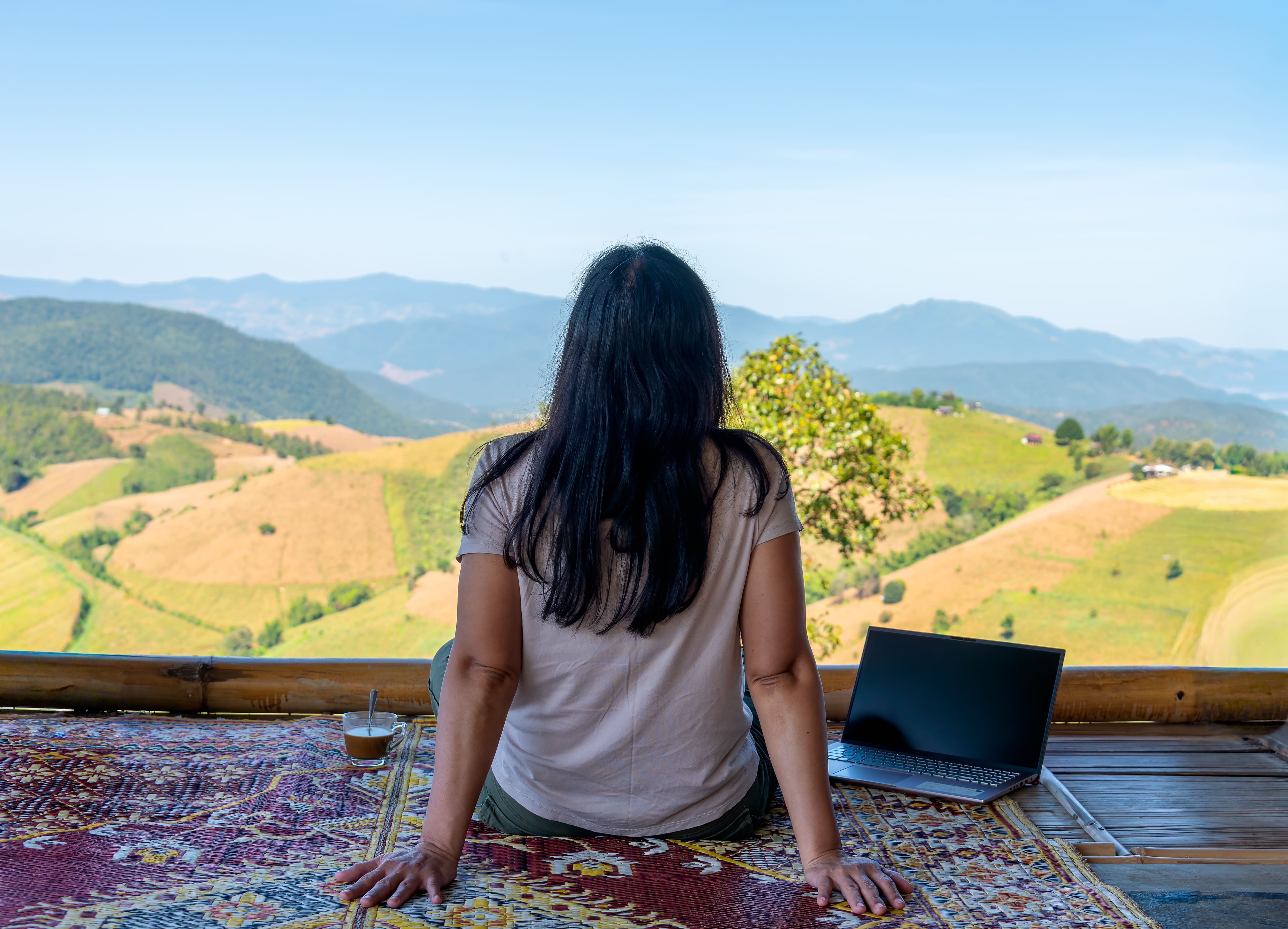 Digitale Nomadin sitzt auf der Terrasse in der Natur