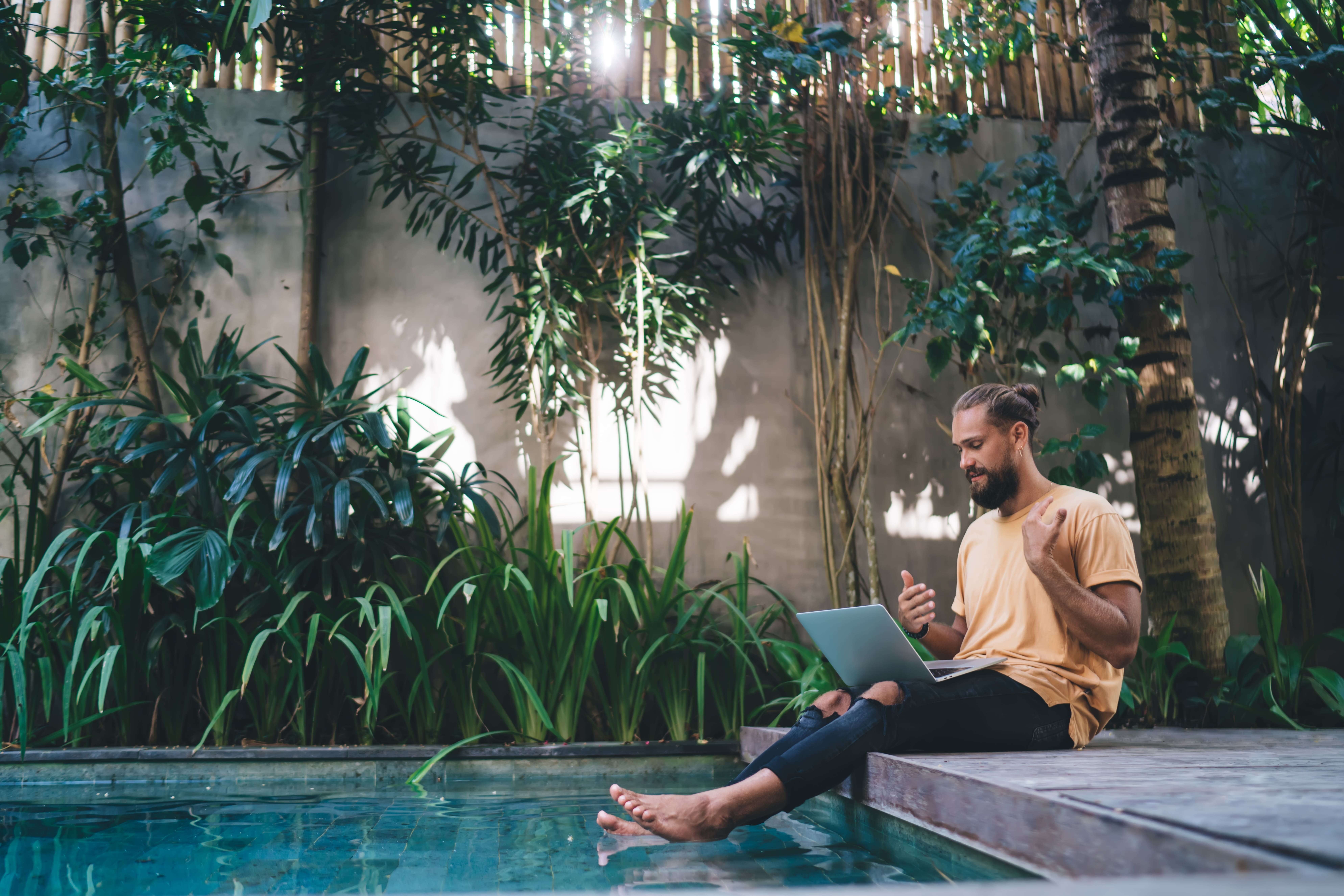 Digitaler Nomade sitzt am Pool