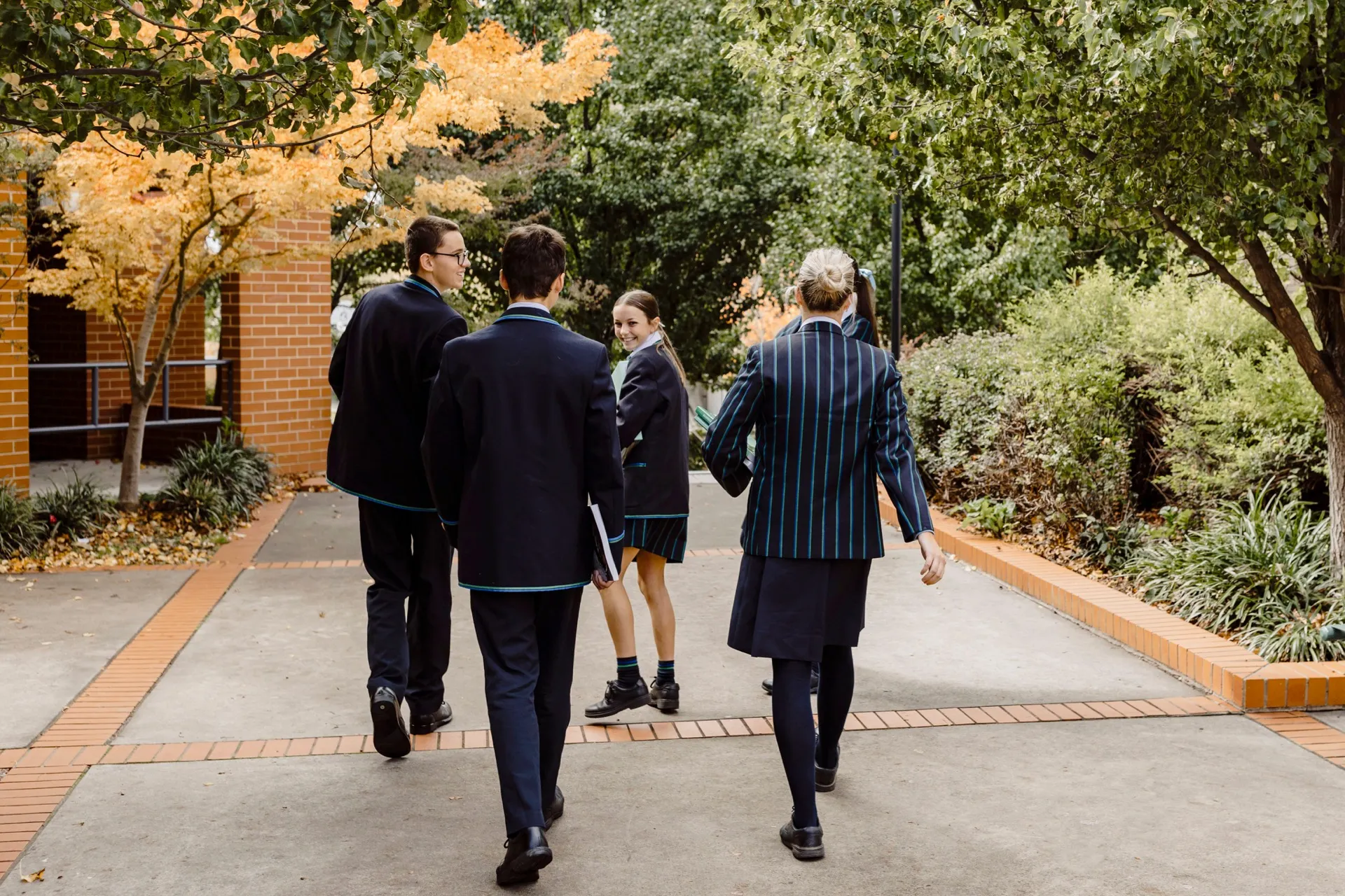 A group of people walking down a sidewalk