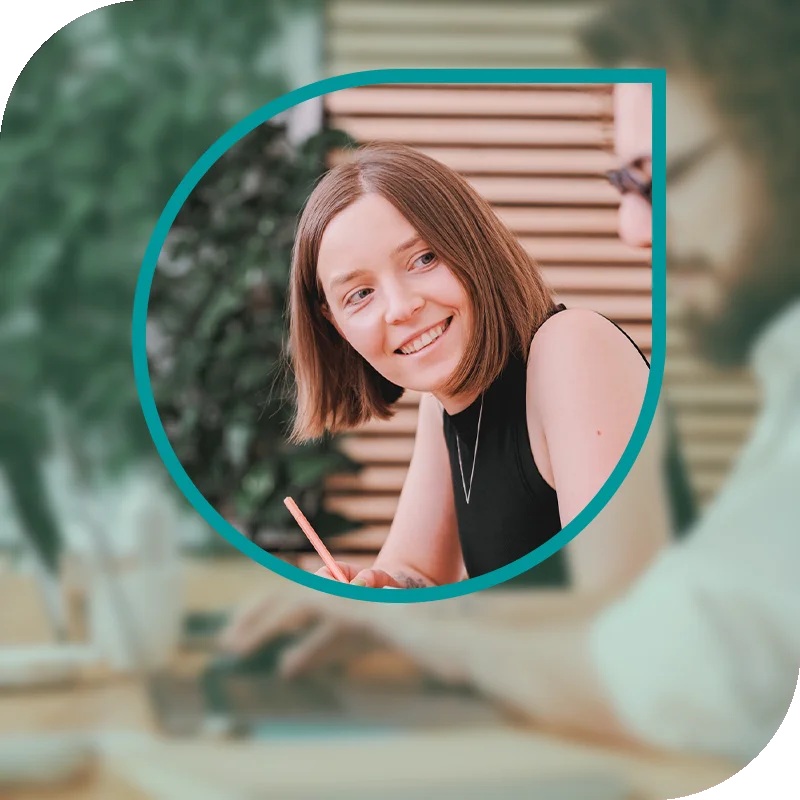 Lächelnde Frau hält einen Laptop fest