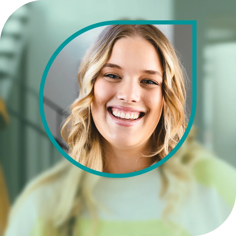 Lächelnde Frau hält einen Laptop fest