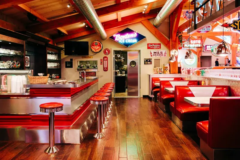 brightly colored diner with stools at a counter and booths