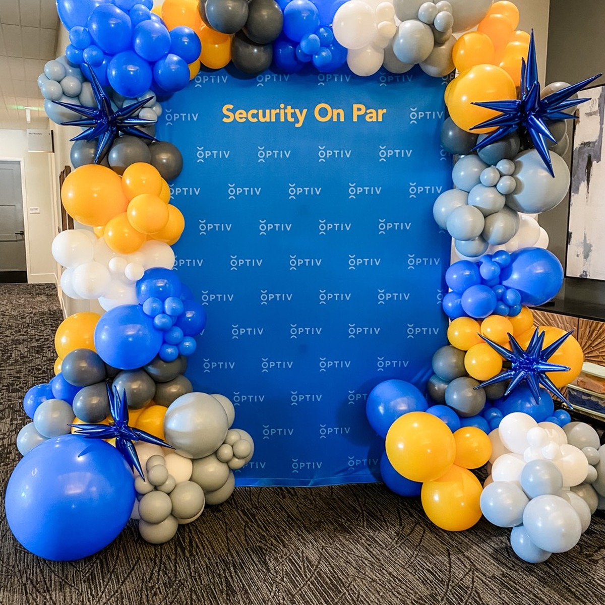 Security On Par branded corporate photo backdrop with balloon clusters