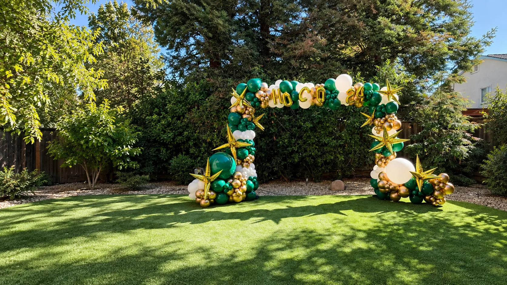 Green, white, and gold homecoming balloon arch with gold stars by Poptastic Parties