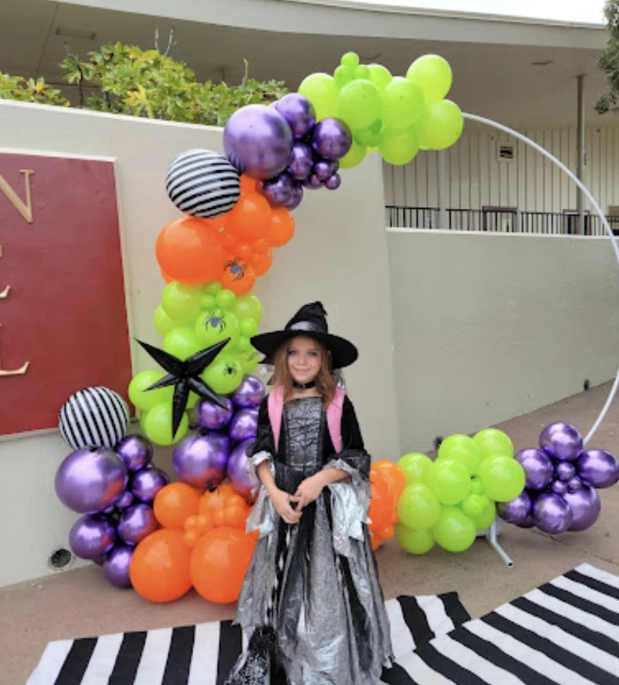 Green, purple, orange and striped balloons around a school Halloween photo backdrop for the Jackson Avenue PTO